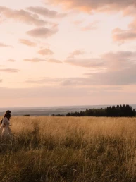 woman in a golden field at sunset