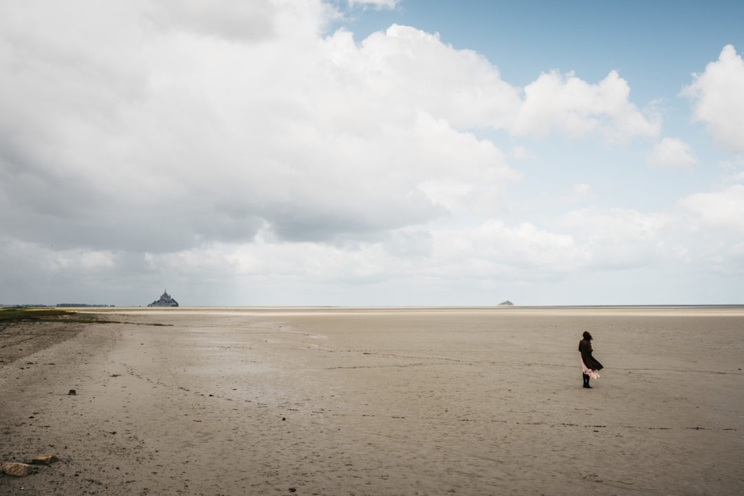 Mont Saint-Michel in the distance, girl standing in the foreground