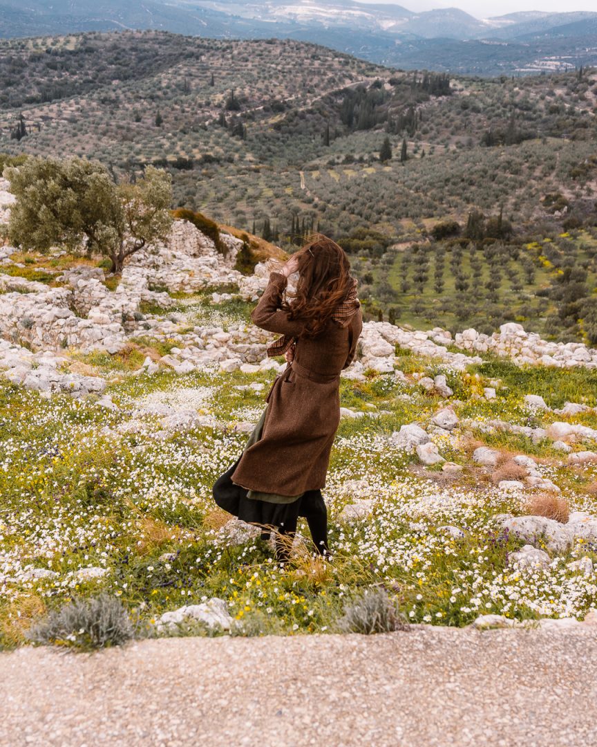 woman in a wildflower field on a windy day