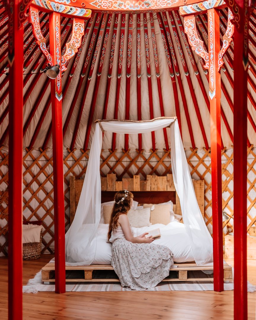 woman sitting on a bed in the zero waste yurt