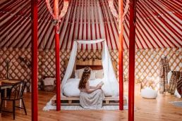 woman sitting on a bed at the zero waste yurt