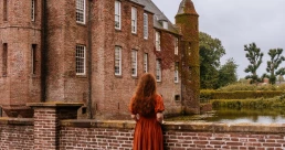 woman in a dress looking at zuylen castle