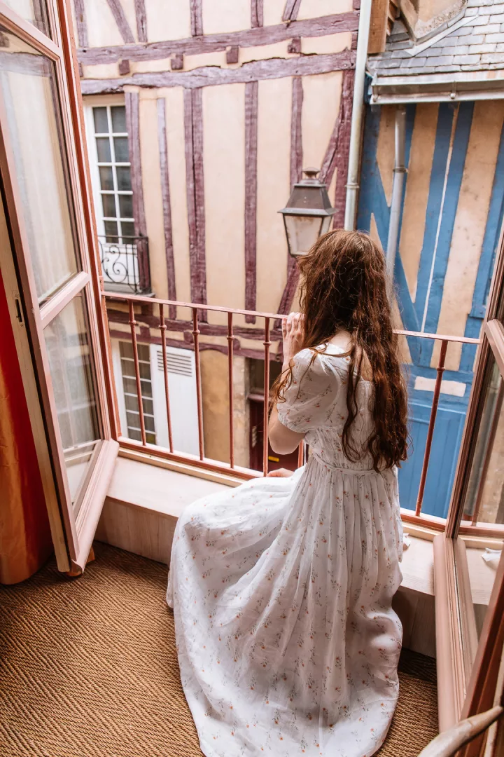 woman looking out the window of logis saint-flaceau in le mans